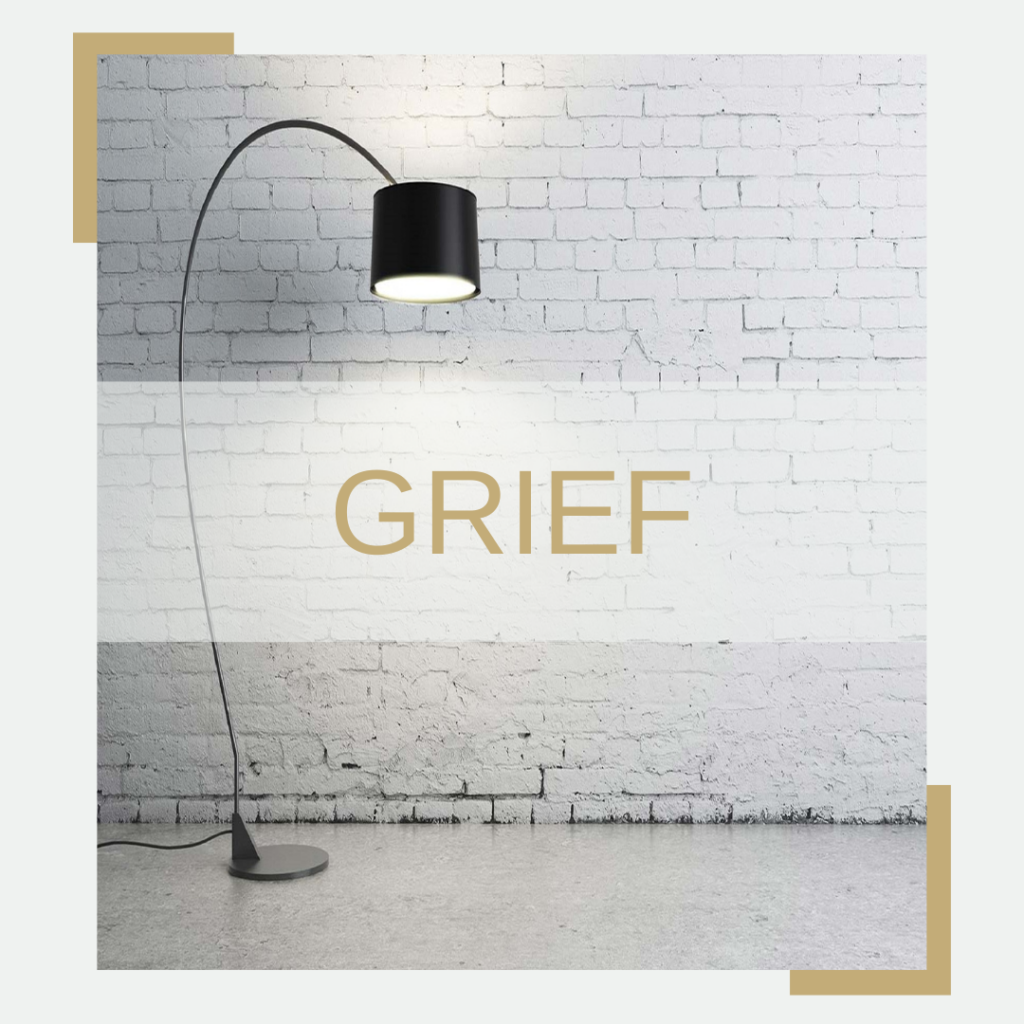Tall black floor lamp with a white brick wall background. The word grief written across the page